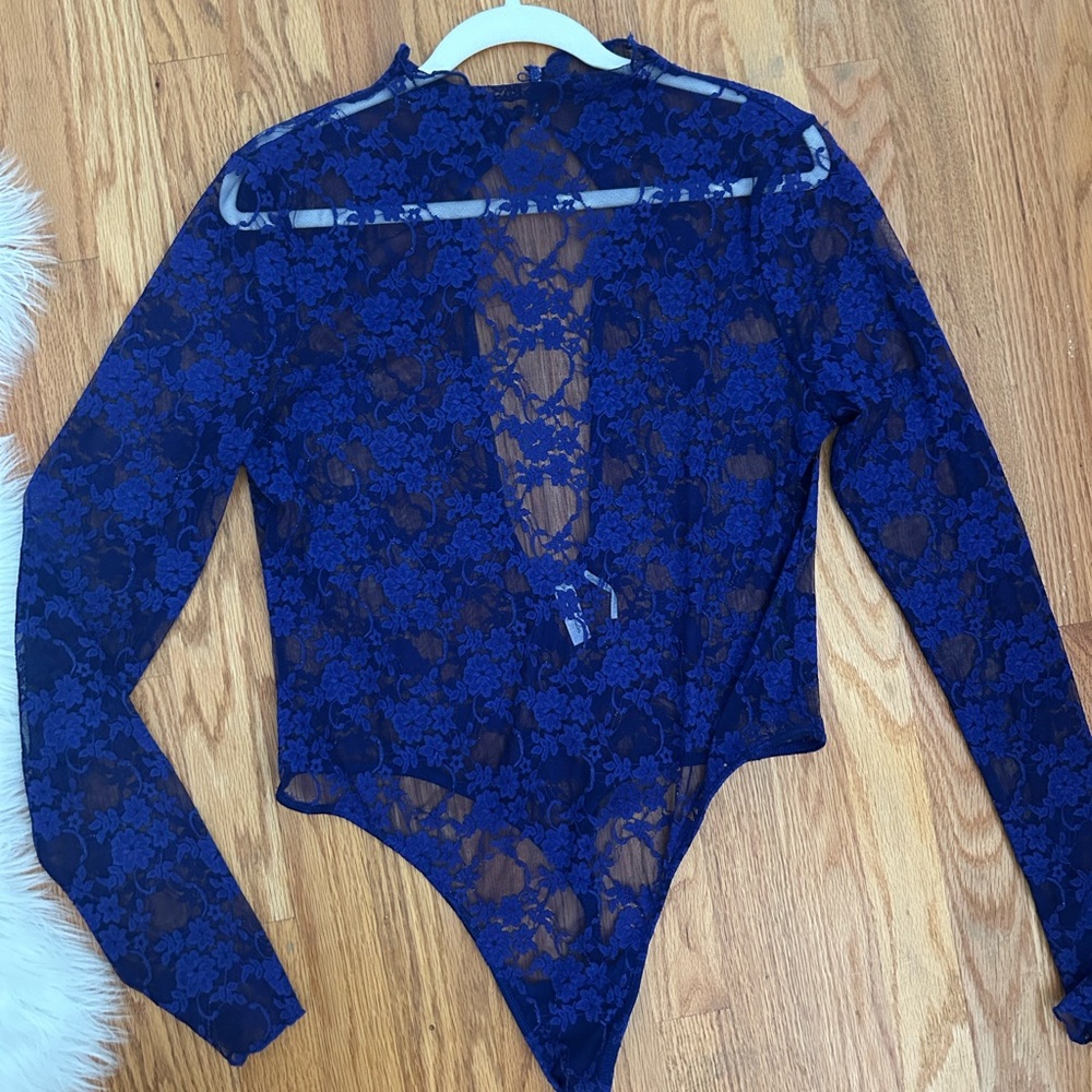 Out from under blue lace bodysuit with long sleeves and open back!